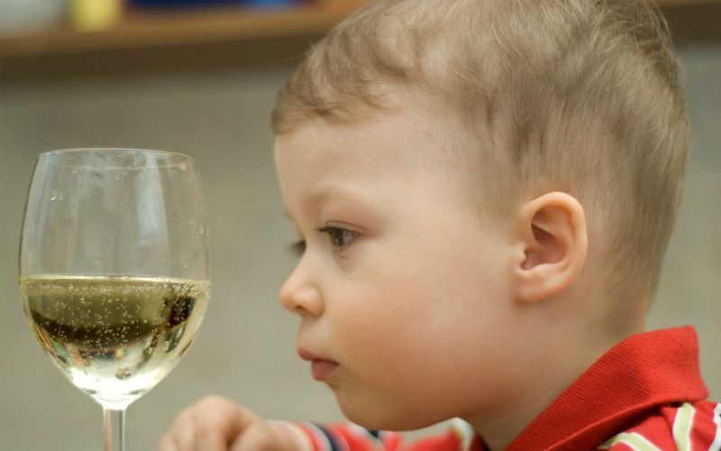 Ребенок смотрит на шампанское